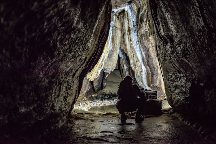 Person Crouching In A Cave 