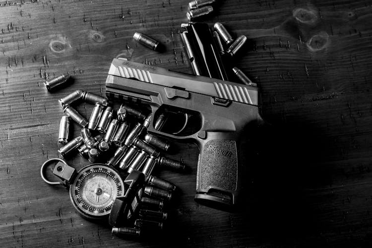 Handgun And Bullets On Wooden Table