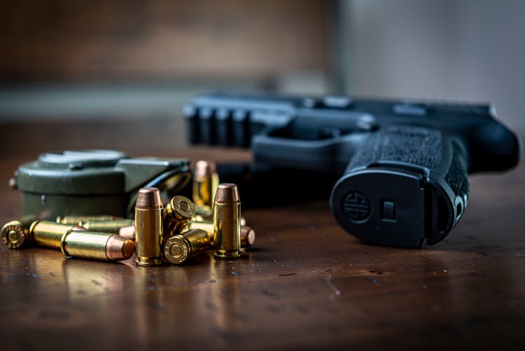 Handgun And Bullets On Wooden Surface