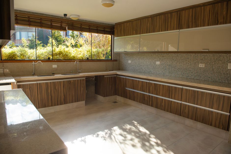 Photo by Rodrigo Simoes on Pexels A spacious modern kitchen with wood cabinetry and large windows inviting ample sunlight.