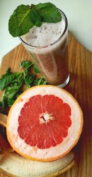 Vibrant grapefruit mocktail garnished with mint, perfect for a refreshing moment.