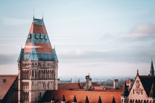 Free Elegant view of the University of Manchester tower with its iconic architecture and surrounding rooftops. Stock Photo