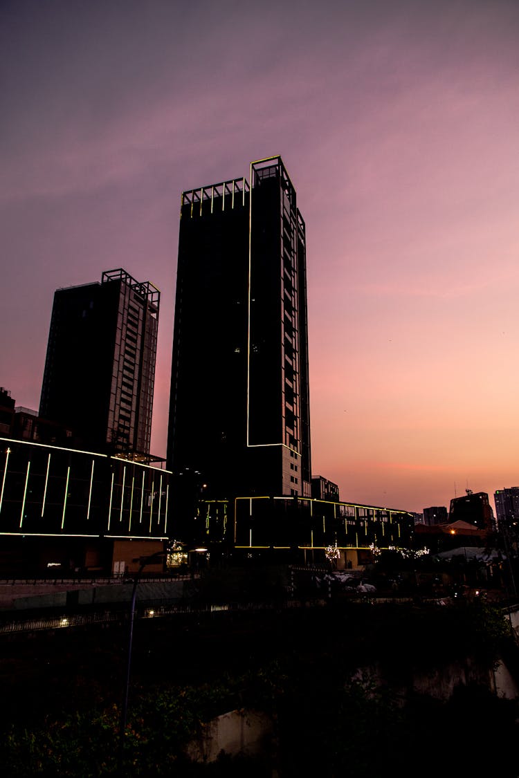 Silhouette Of Two Buildings In The City During Sunset