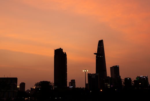 Silhouette of a city skyline at twilight with a vibrant sunset backdrop.