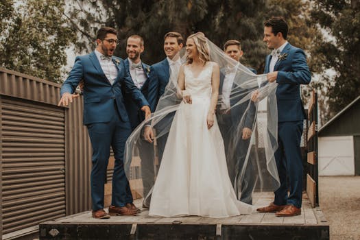 Bride and groomsmen laughing together outdoors in Santa Monica, CA, wearing elegant attire.