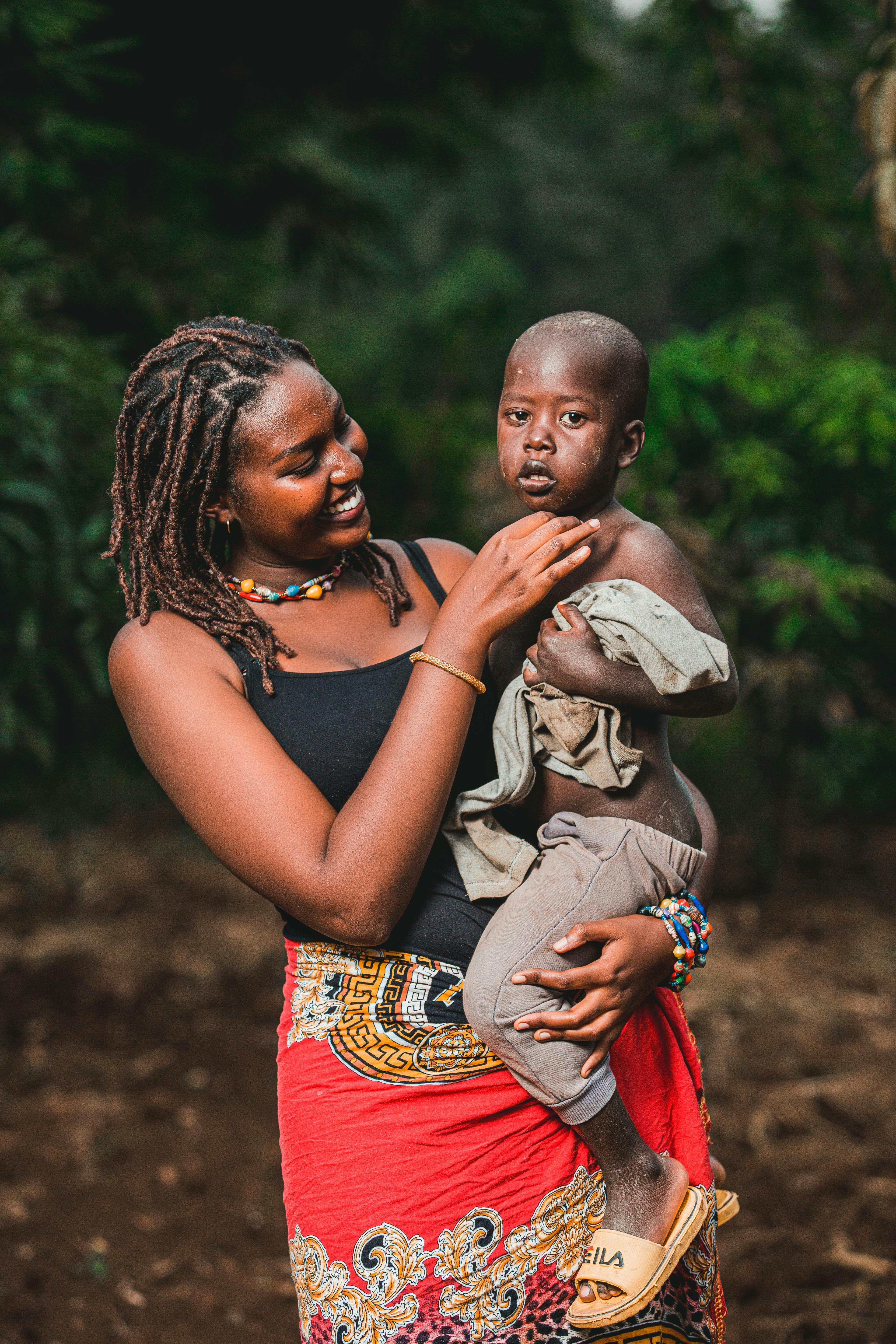 a mother carrying her child covered in dirt