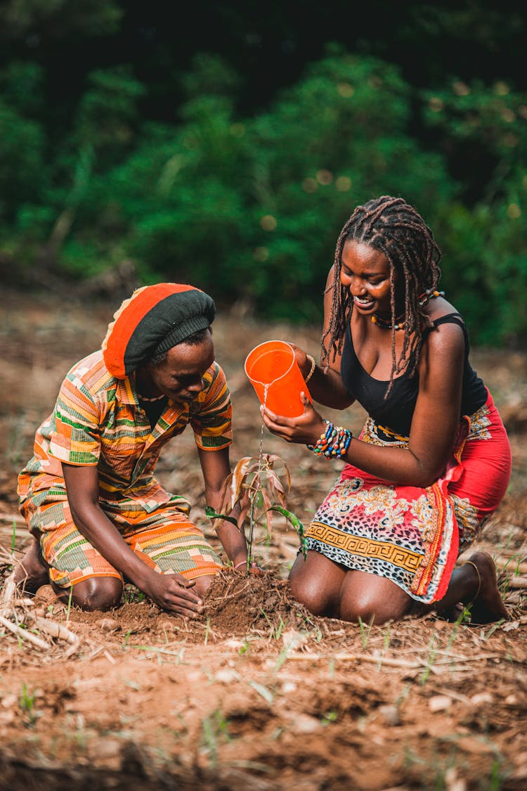 A Couple Watering A Plant