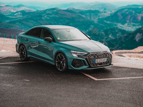 Sleek luxury car parked on a mountain road with a panoramic view.