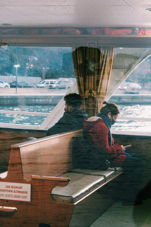 View of Passengers Wearing Face Mask while Sitting on the Wooden Benches 