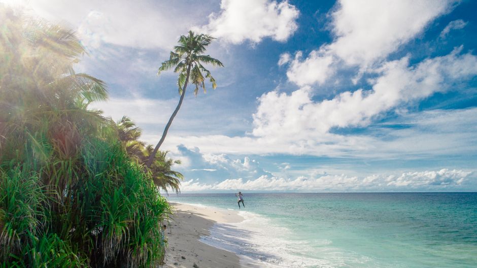 A traveler relaxing peacefully on a beautiful Maldives beach, emphasizing the benefits of travel insurance.