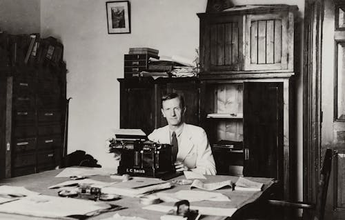 Writer Sitting At Desk With Typewriter