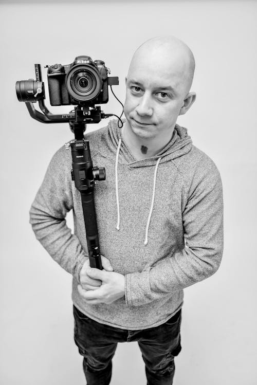 A Man in Gray Hoodie Holding a Camera