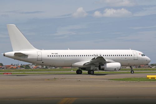 Free A white passenger airliner preparing for takeoff on a sunny day at the airport. Stock Photo