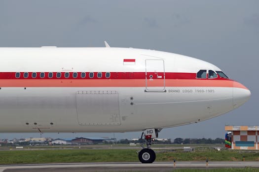 Side view of a vintage-styled airplane on a runway, displaying classic branding and logo.