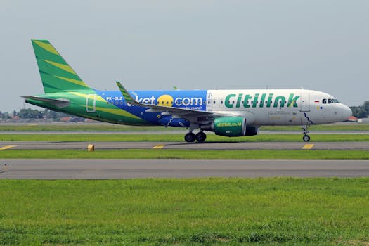 Citilink passenger airplane on runway, showcasing vibrant livery at airport.