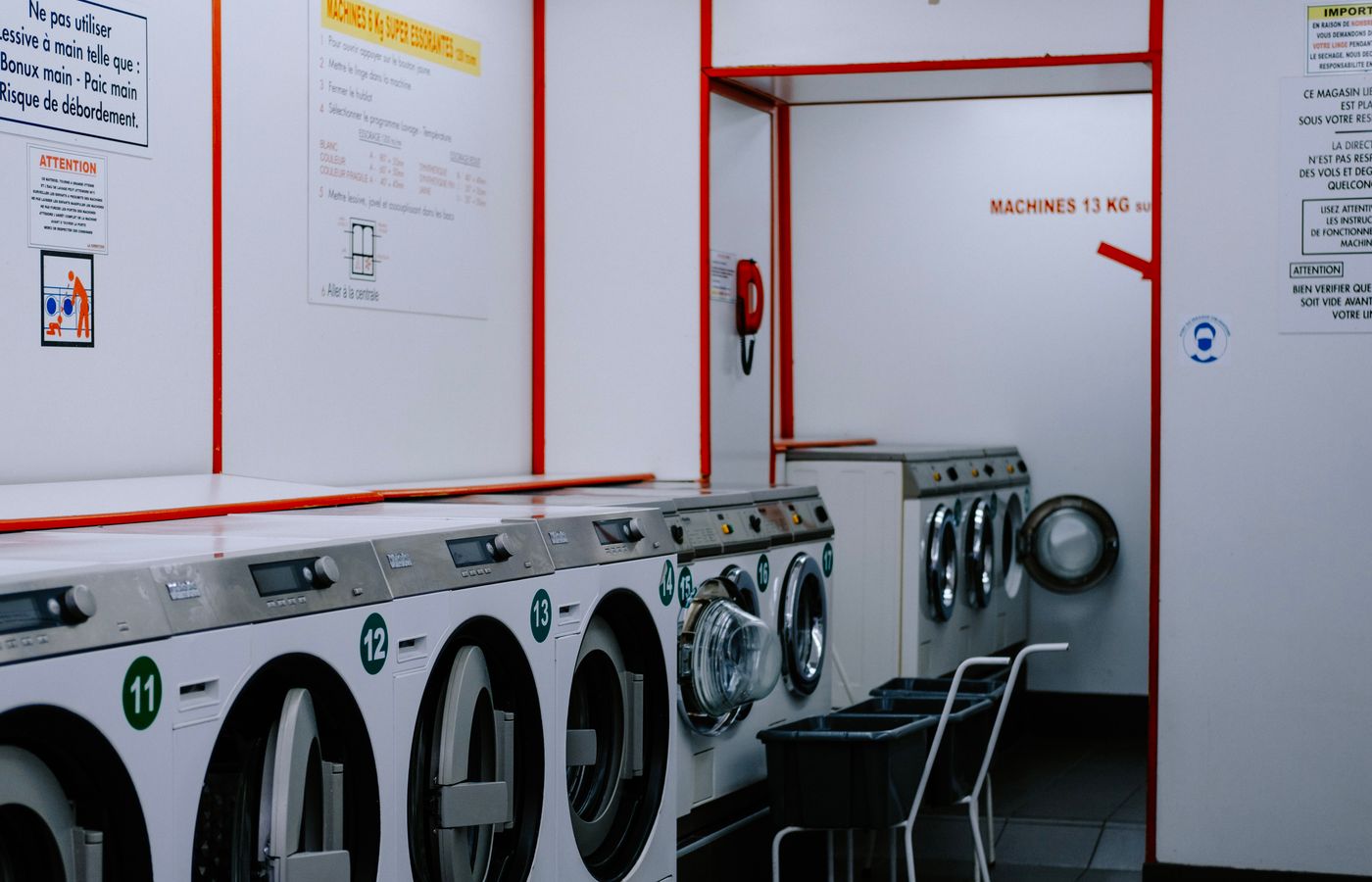 Inside a laundromat with washing machines lined up against the wall.