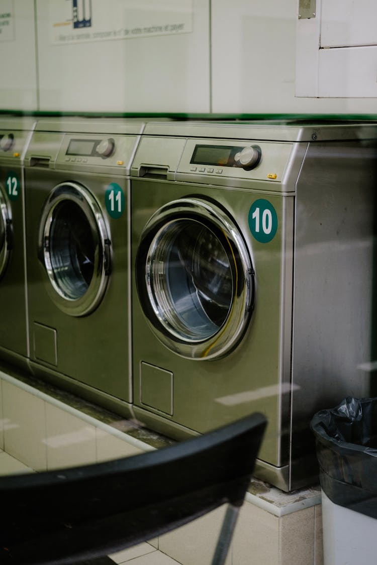 Industrial Washing Machines Lined Up Under Wall