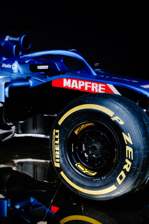 Free High-detail close-up of a racing car tire and side panel in a studio setting. Stock Photo