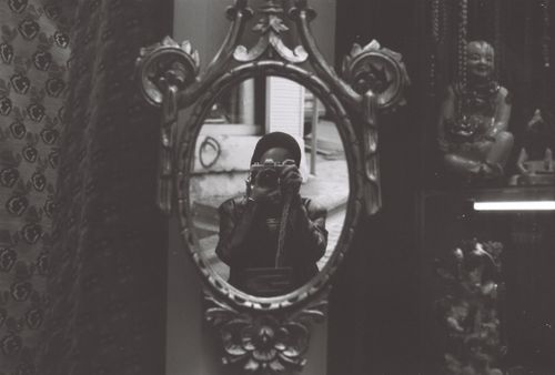 Free A photographer captures their reflection in an ornate mirror in grayscale. Stock Photo