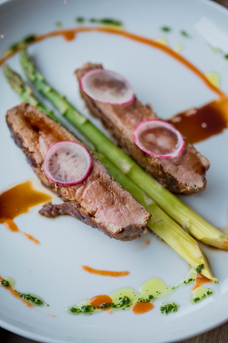 Asparagus With Meat Served On White Plate With Sauce