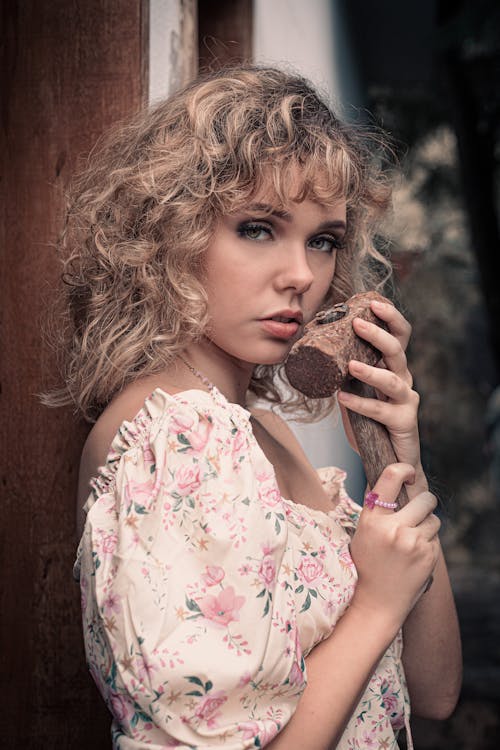 Woman Holding a Rusty Hammer near Her Face 