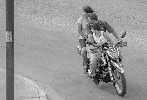 Black and White Photo of a Family Riding a Motorcycle