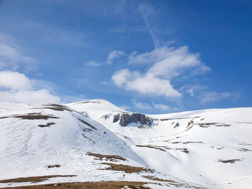 Free Breathtaking winter landscape featuring a snow-covered mountain range beneath a vibrant blue sky. Stock Photo