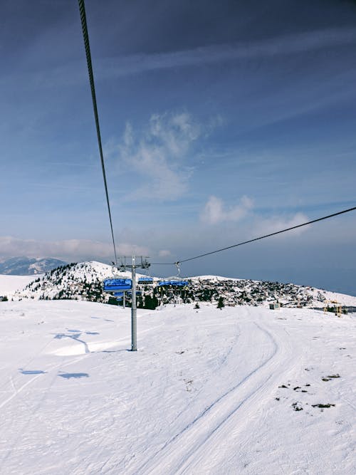 Free Cable Cars over Snow Covered Ground Under White Clouds and Blue Sky Stock Photo