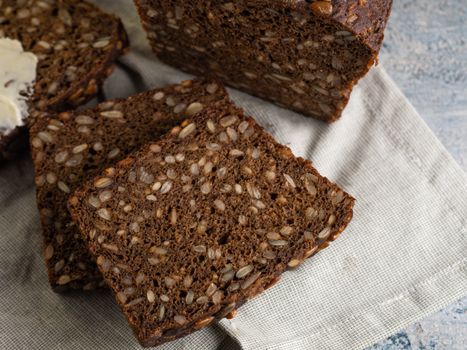 Close-up of sliced Danish rye bread with seeds on a cloth.