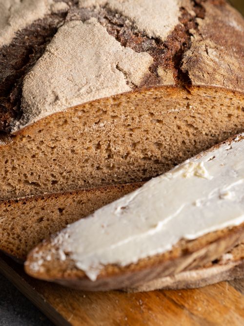Free Rustic sliced bread with butter spread, highlighting homemade and artisanal baking. Stock Photo