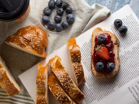 Enjoy a tasty breakfast with fresh blueberries, jam, and sesame seed bread.