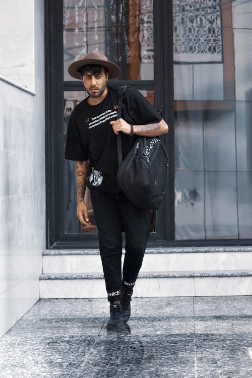 Free Man in All Black Outfit Wearing a Brown Fedora Hat  Stock Photo