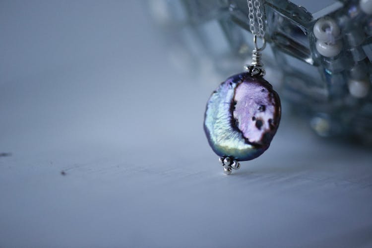 Silver Chain Necklace With Amethyst Orb Pendant In Close Up Photography