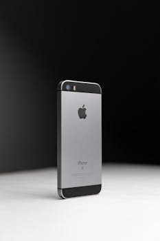 Elegant smartphone standing on minimalist surface with a dark, contrasting background.