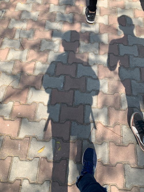 Shadow of boy walking on concrete padded road