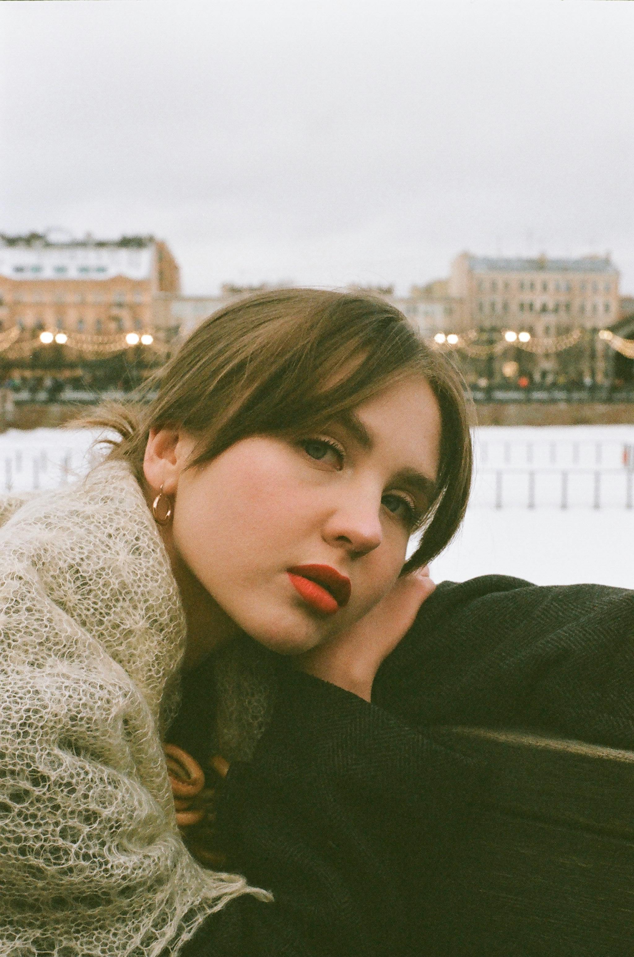 Sophisticated outdoor portrait of a young woman with a serene expression.