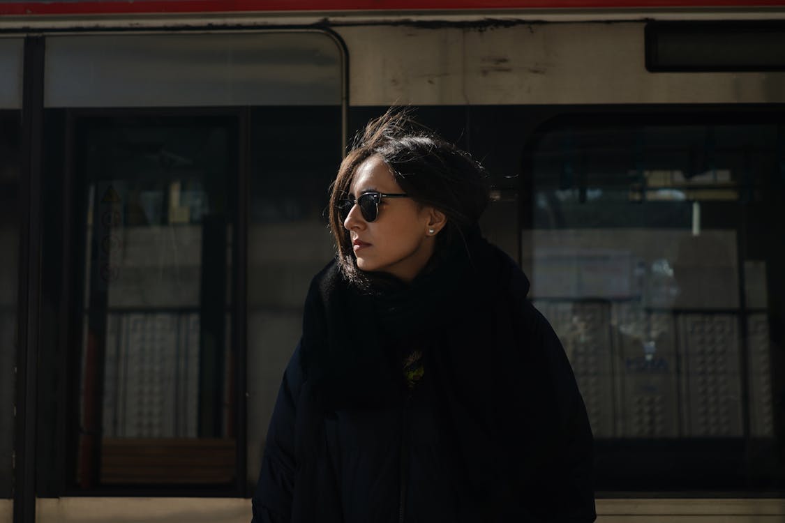 A Woman in a Black Coat and Sunglasses