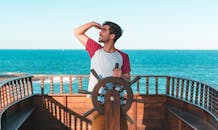 Man Holding Ship's Wheel