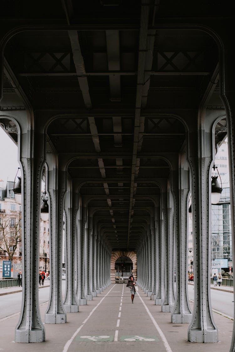 A Woman Walking Under A Bridge