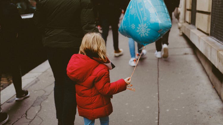 Girl In Red Jacket Holding Blue Balloon