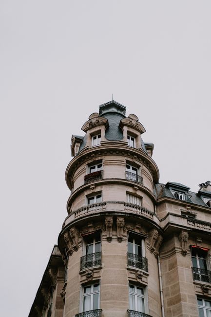 A classic gothic-style building corner against a white sky, showcasing detailed architecture.