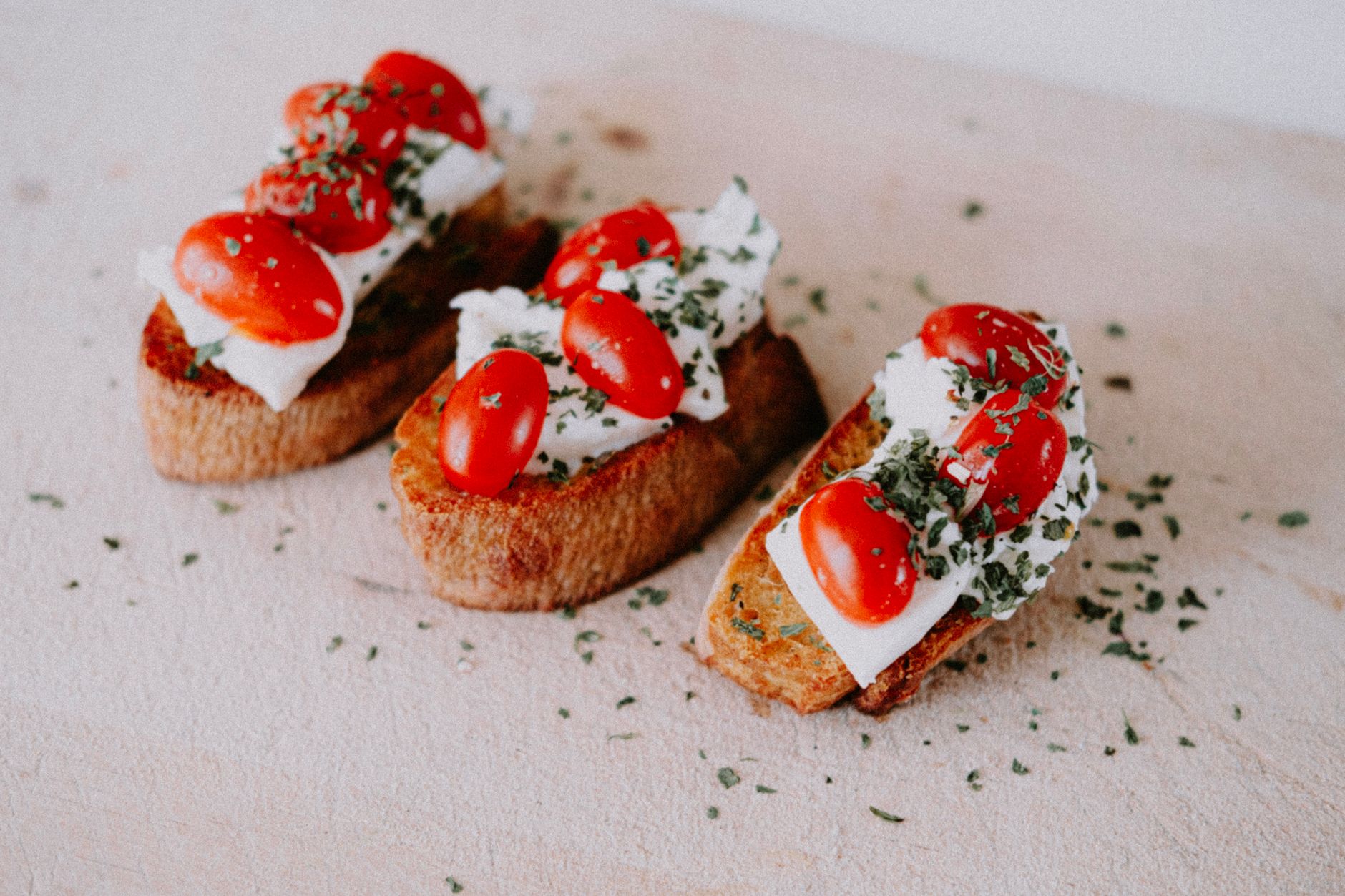 Close-up of crostini with ricotta and goat cheese topped with lemon zest