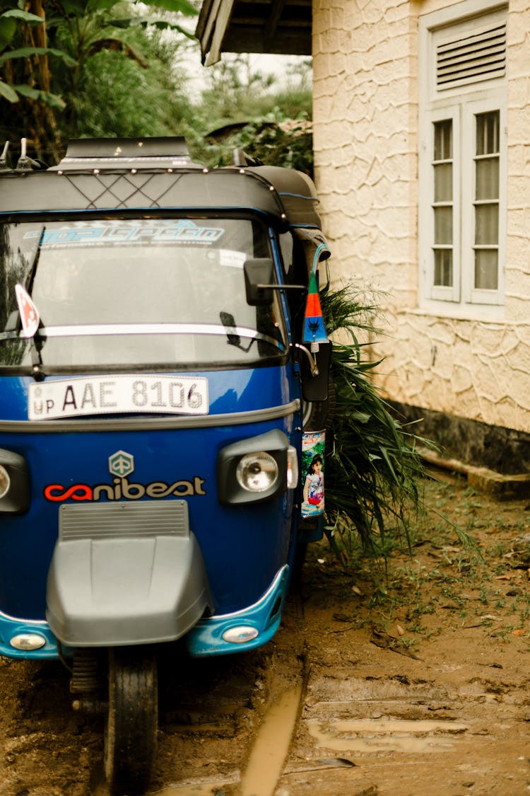 Piaggio Ape Motorcycle Parked Beside A Family House