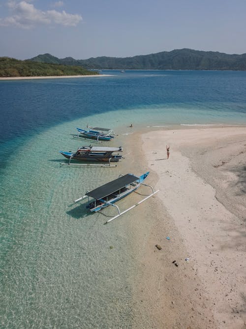 Gray and Blue Boats Docked on Seashore