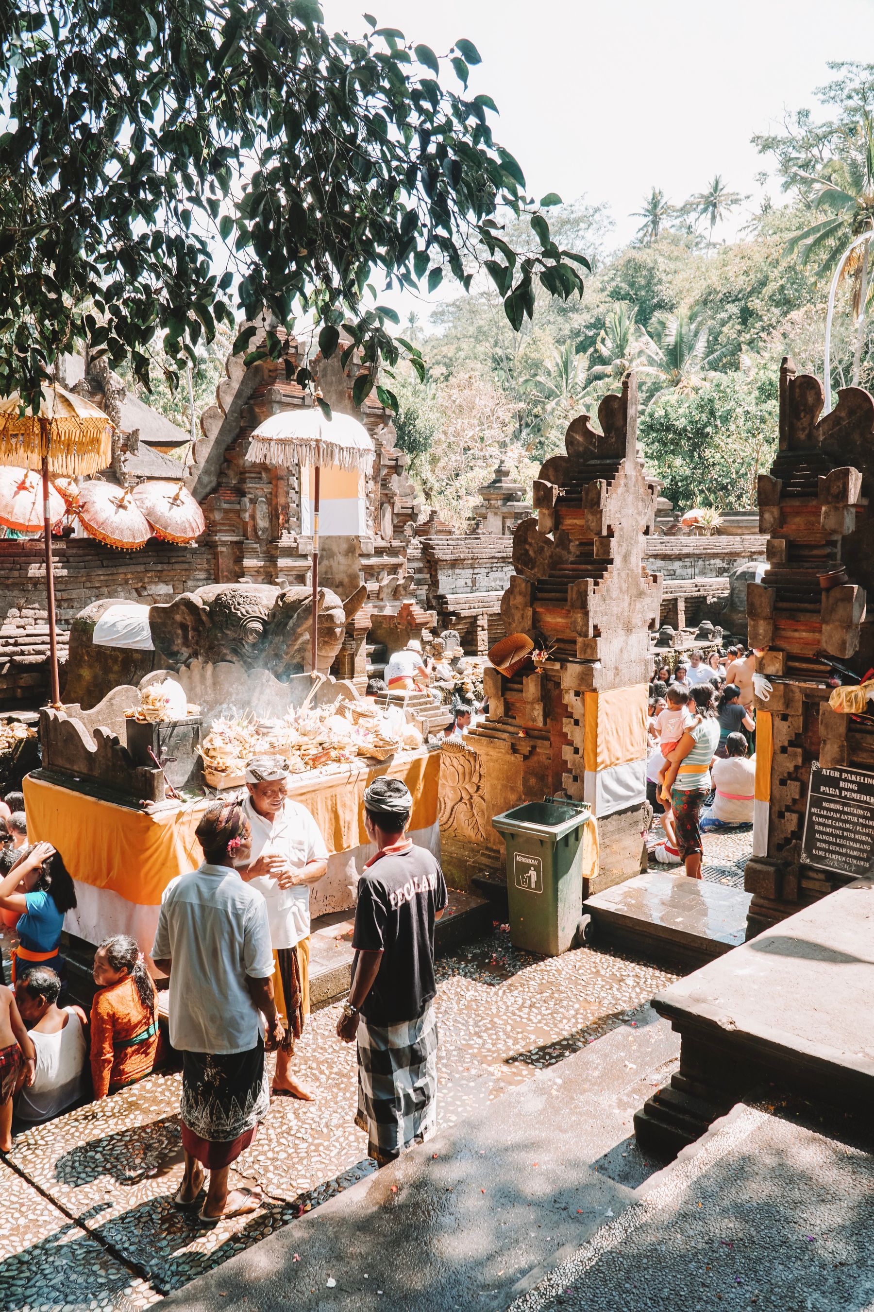 People moving among traditional stalls and carved architecture at Ubud Market in Bali