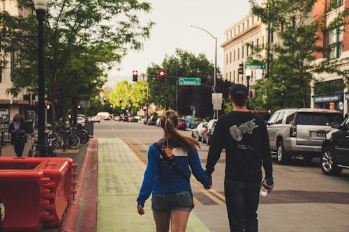 Free Man and Woman Holds Hands While Walking Stock Photo