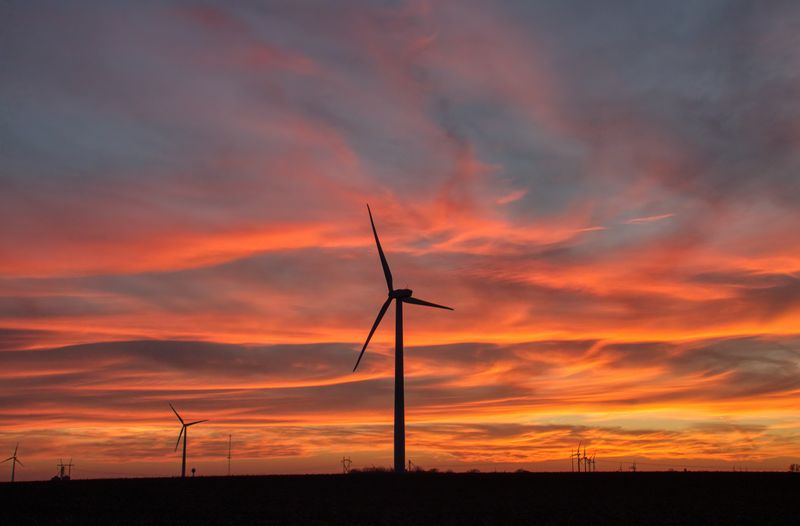 A single wind turbine against a deep orange sunset — photo by Tom Fisk on Pexels