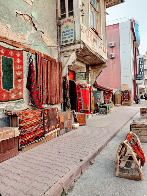Free Street view of a Turkish rug shop with vibrant carpets displayed outside, showcasing traditional craftsmanship. Stock Photo