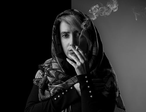 Free A Woman Wearing a Headscarf while Smoking Cigarette Stock Photo