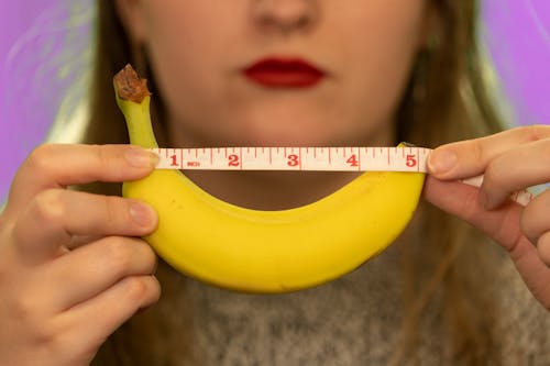 Woman measuring banana, average penis length